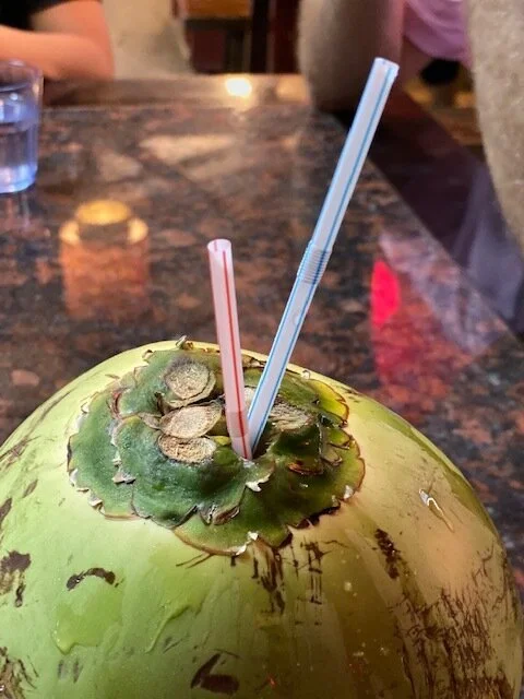 Fresh green coconut drink with a straw