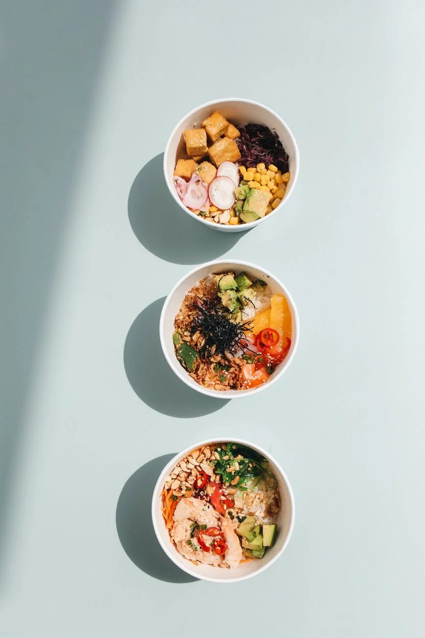 Four colorful smoothie and poke bowls